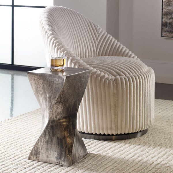 Tarnished silver hourglass accent table beside chair in modern living room